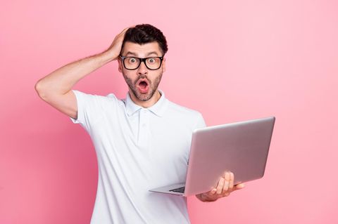 Apple Black Friday Week: Junger Mann mit MacBook greift sich an den Kopf