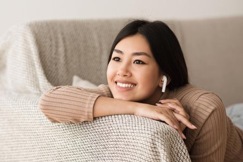 Apple Black Friday Week: Junge Frau lächelt mit AirPods im Ohr