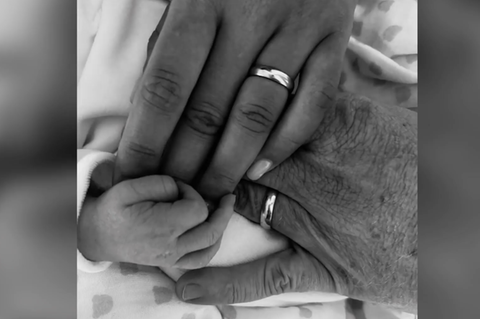 Die Hand eines Neugeborenen in einer erwachsenen Hand