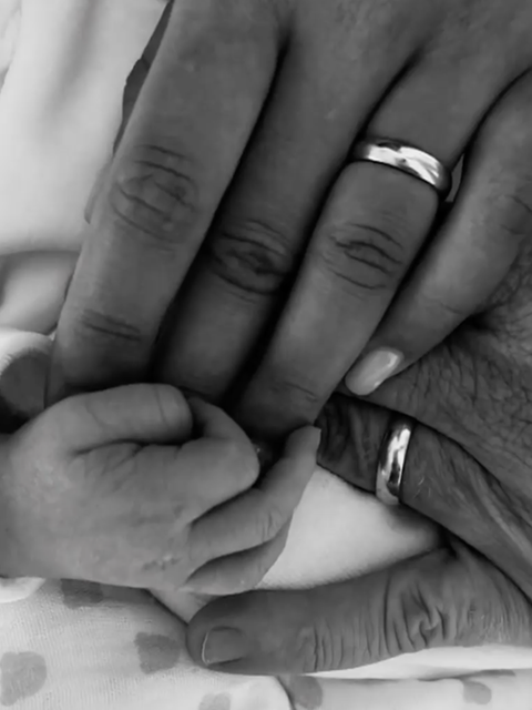 Die Hand eines Neugeborenen in einer erwachsenen Hand