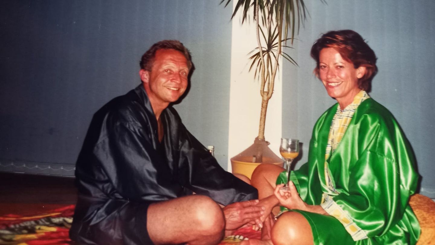 Sex im Alter: Ein Mann und eine Frau, beide leichtbekleidet, sitzen auf dem Boden und halten Händchen.