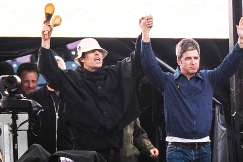 Liam und Noel Gallagher triumphierend auf der Bühne.