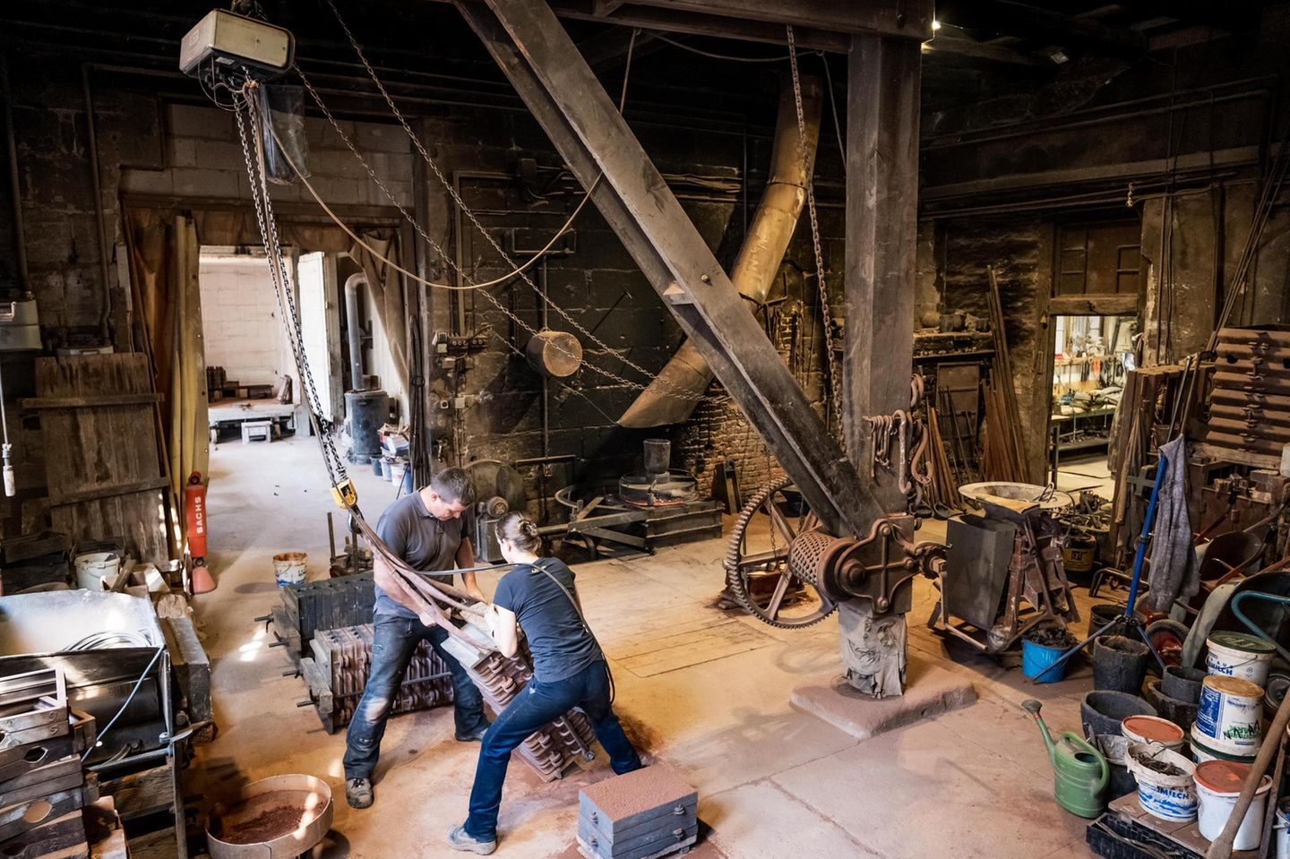 Wie vor 150 Jahren: Ein alter Kran aus Holz bewegt die zentnerschweren Sandgussformen in der Kunstgießerei Lenz in Nürnberg