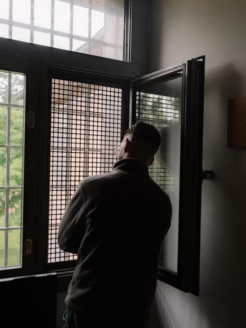 Mann vor einem Gitterfenster im Jugendgefängnis