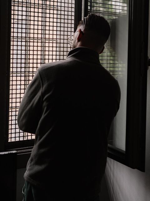 Mann vor einem Gitterfenster im Jugendgefängnis