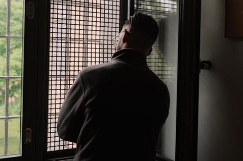 Mann vor einem Gitterfenster im Jugendgefängnis