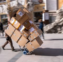 Ganz schön viel zu tun: ein Paketbote bei der Arbeit. Foto: Peter Kneffel/dpa