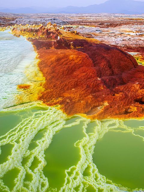 Die rot-braune Dallol Vulkanlandschaft, welche von weißen bis blauen Naturbecken und Salztürmen durchsäht ist