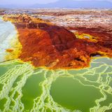 Die rot-braune Dallol Vulkanlandschaft, welche von weißen bis blauen Naturbecken und Salztürmen durchsäht ist