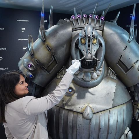 Eine Propstore-Mitarbeiterin steht neben einem Mondoshawan in Originalgröße aus dem Film Das fünfte Element