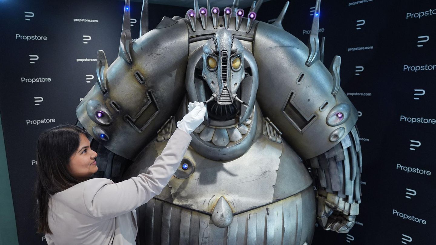 Eine Propstore-Mitarbeiterin steht neben einem Mondoshawan in Originalgröße aus dem Film Das fünfte Element