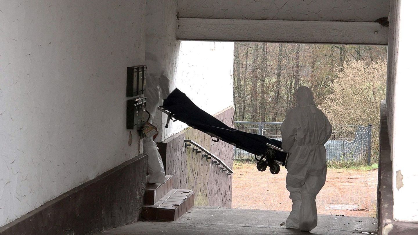 Beamte der Spurensicherung bringen eine Trage in ein Wohnhaus. Foto: Thorsten Kremers/dpa