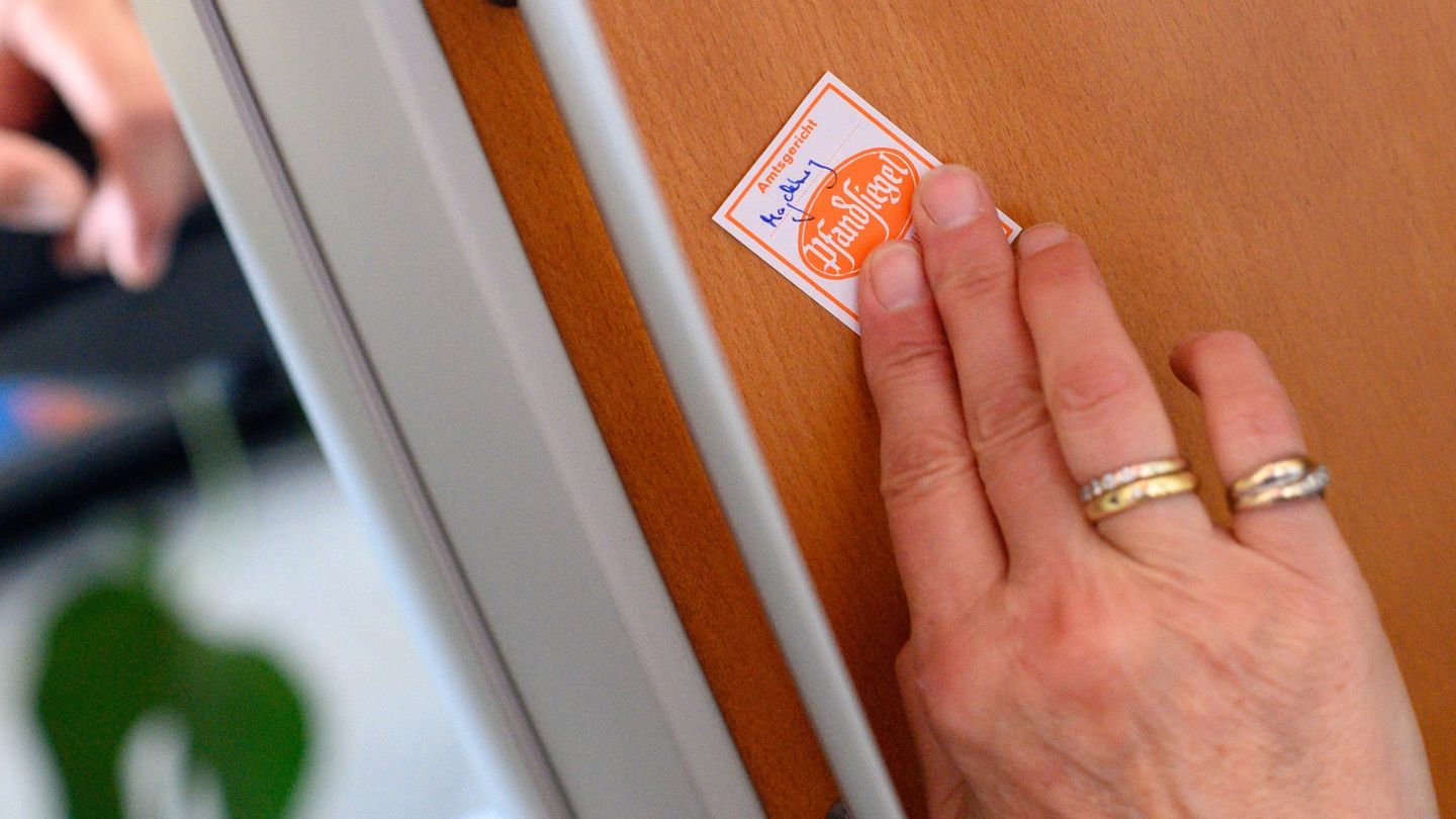 Eine Gerichtsvollzieherin klebt ein Pfandsiegel auf ein technisches Gerät. (Symbolbild) Foto: Klaus-Dietmar Gabbert/dpa