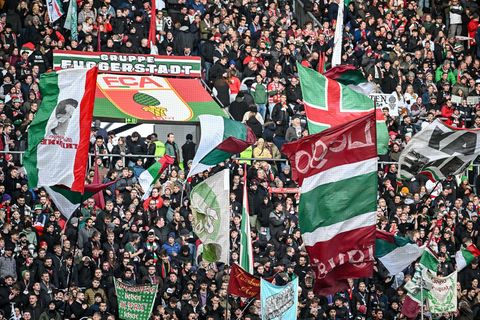 Fans des FC Augsburg schwenken ihre Fahnen in der WWK-Arena. (Archivfoto) Foto: Harry Langer/dpa