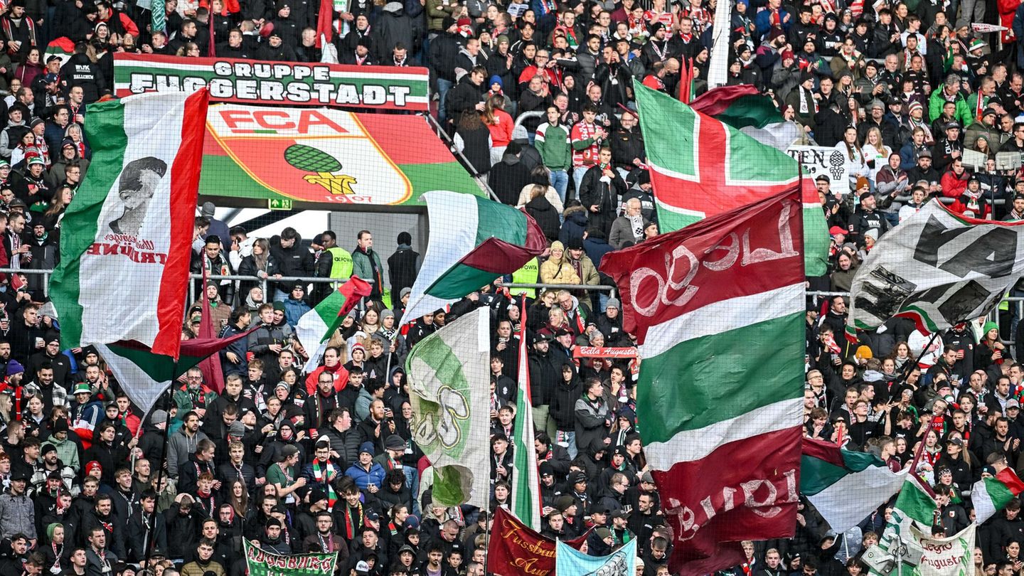 Fans des FC Augsburg schwenken ihre Fahnen in der WWK-Arena. (Archivfoto) Foto: Harry Langer/dpa