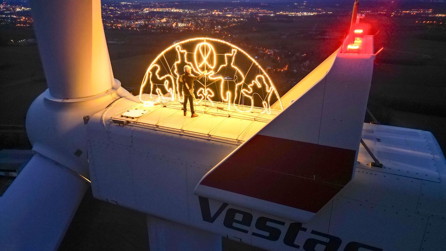 Steffen Flämig prüft die Beleuchtung an einem überdimensionalen Schwibbogen auf einem Windrad. Foto: Jan Woitas/dpa