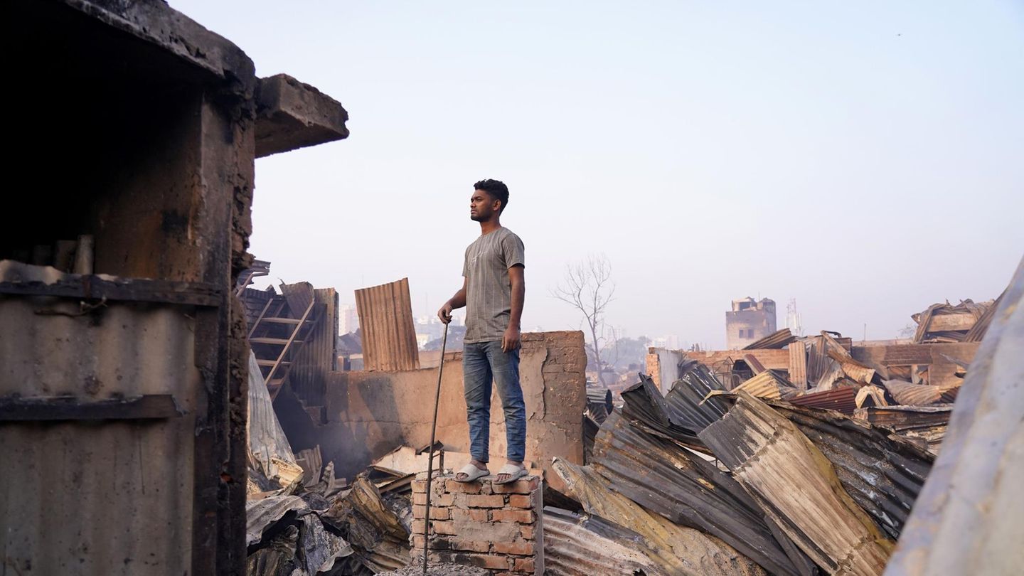 Bangladesch, Dhaka: Ein Mann steht auf einer Mauer eines abgebrannten Hauses. Ein Feuer hat das Korail-Slum von Dhaka verwüstet und innerhalb weniger Stunden Tausende von Häusern in Schutt und Asche gelegt. Nun gibt es für die plötzlich obdachlos Gewordenen noch düsterere Aussichten als eh schon