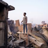Bangladesch, Dhaka: Ein Mann steht auf einer Mauer eines abgebrannten Hauses. Ein Feuer hat das Korail-Slum von Dhaka verwüstet und innerhalb weniger Stunden Tausende von Häusern in Schutt und Asche gelegt. Nun gibt es für die plötzlich obdachlos Gewordenen noch düsterere Aussichten als eh schon