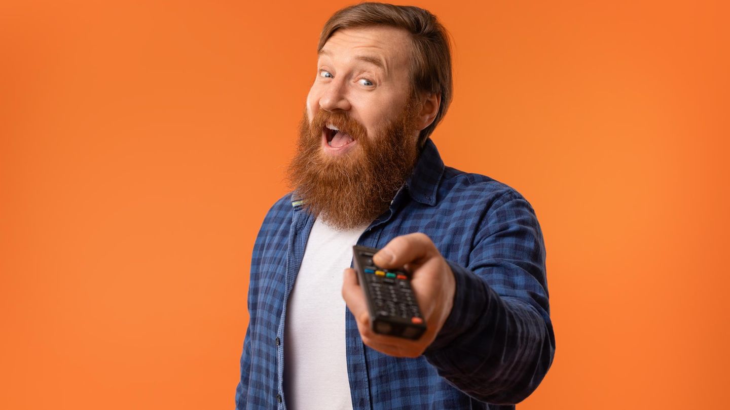 Black Friday Fernseher 2025: Ein Mann hält freudig eine Fernbedienung in der Hand