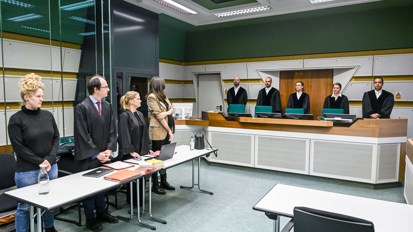 Im Gerichtssaal stehen Anwälte (l) mit der Klägerin und die Richter der 1. Kammer des Verwaltungsgerichts. Foto: Jens Kalaene/dp