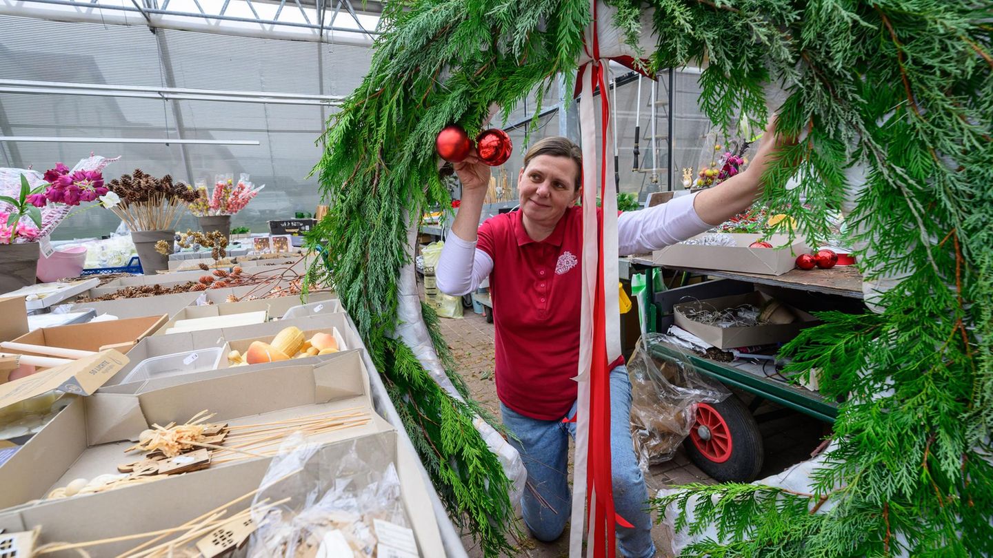 Eine Frau präsentiert einen großen Adventskranz