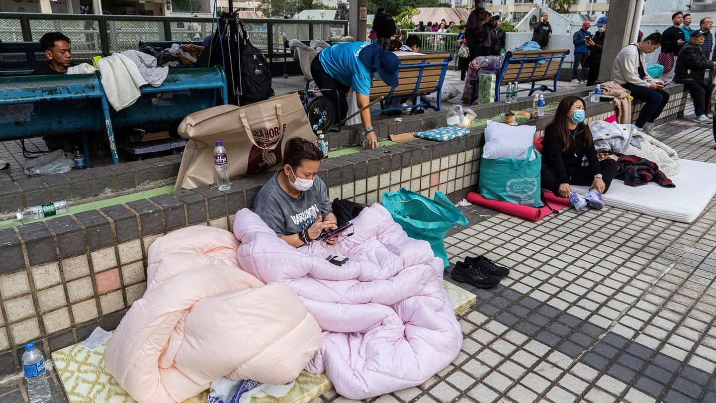 Sie sind mit dem Leben davongekommen, aber ob sie nur Besitztümer oder auch liebe Menschen verloren haben, wissen sie wahrscheinlich noch gar nicht: Anwohner ruhen sich nach dem Brand im Wang Fuk Court, einer Wohnsiedlung in Hongkong, aus