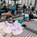 Sie sind mit dem Leben davongekommen, aber ob sie nur Besitztümer oder auch liebe Menschen verloren haben, wissen sie wahrscheinlich noch gar nicht: Anwohner ruhen sich nach dem Brand im Wang Fuk Court, einer Wohnsiedlung in Hongkong, aus