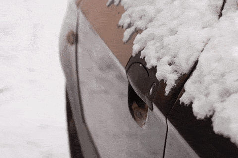 Ein Mann versucht im Winter sein Auto mit dem Schlüssel zu öffnen