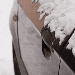 Ein Mann versucht im Winter sein Auto mit dem Schlüssel zu öffnen