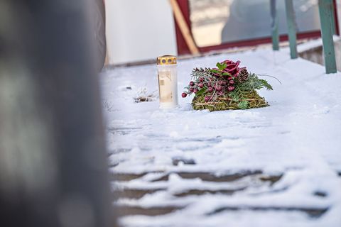 Vor dem Firmengebäude, in dem die Leichen der beiden Söhne gefunden wurden, liegen eine Kerze und ein Kranz. Foto: Jason Tschepl