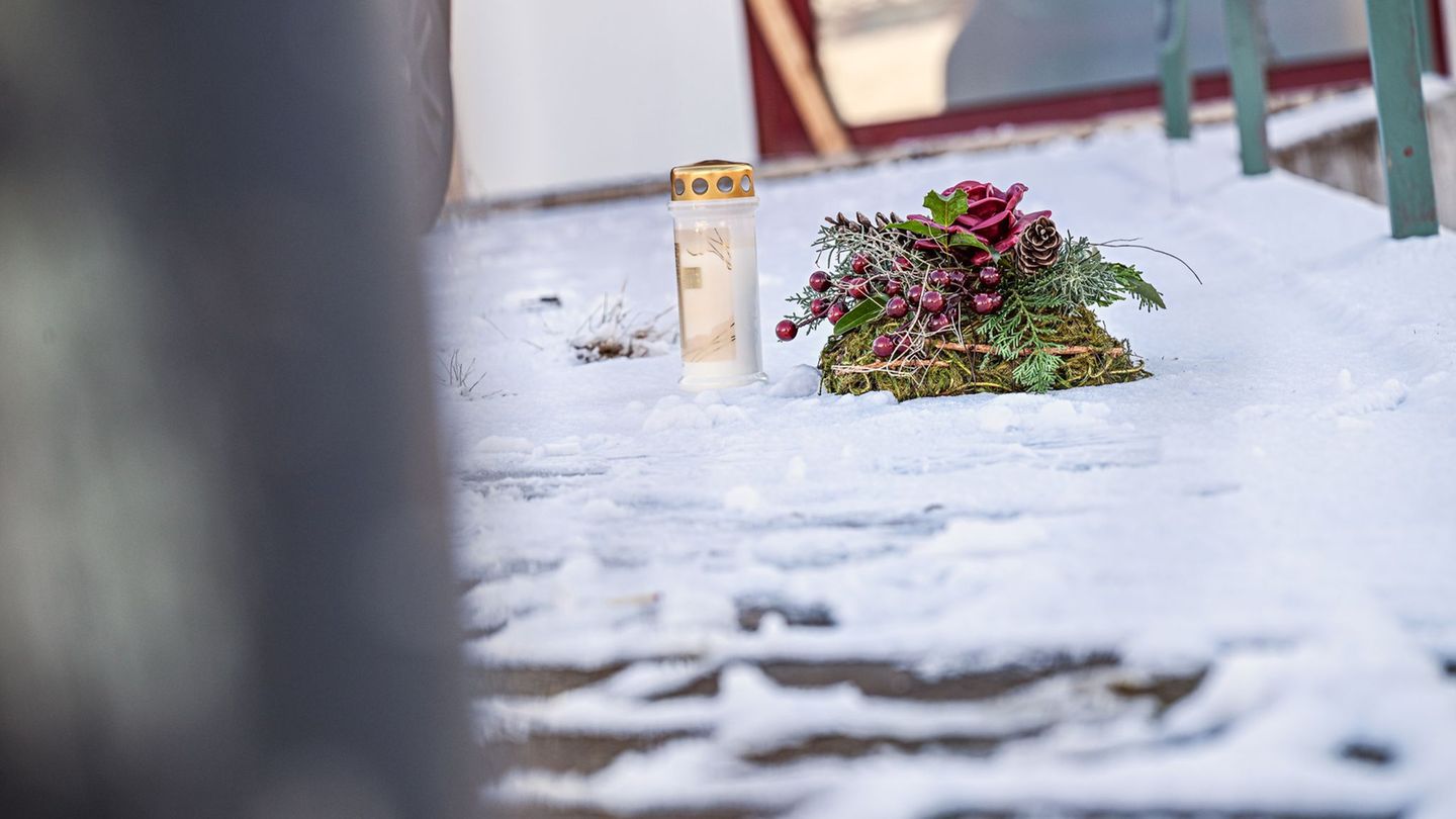 Vor dem Firmengebäude, in dem die Leichen der beiden Söhne gefunden wurden, liegen eine Kerze und ein Kranz. Foto: Jason Tschepl