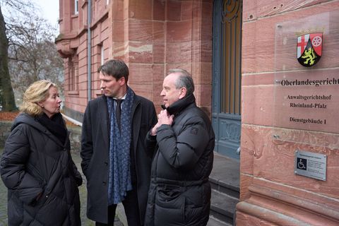 Anwalt Hecken (Mitte) steht mit den Eltern eines Flutopfers vor dem Koblenzer Oberlandesgericht. Foto: Thomas Frey/dpa