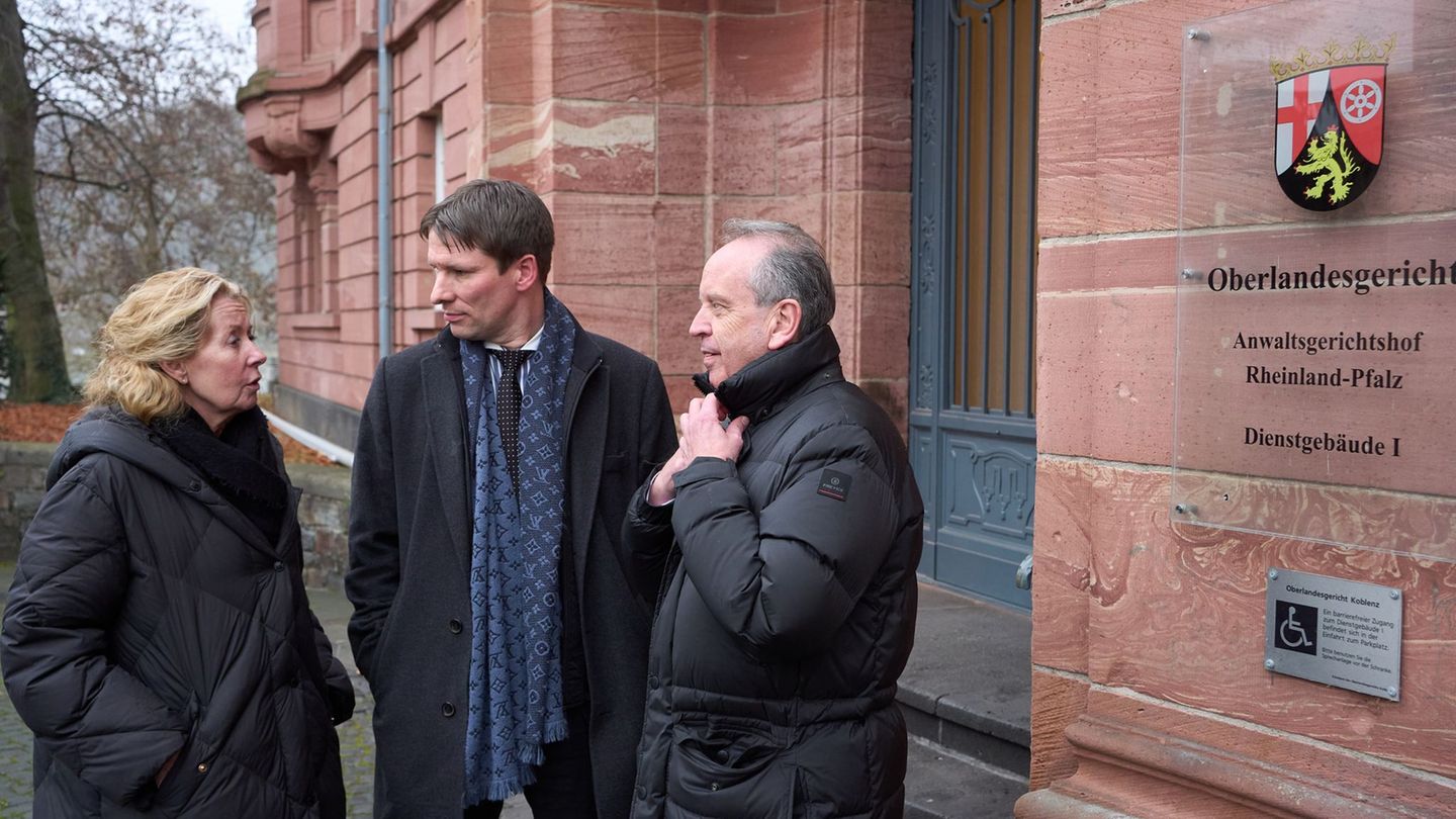 Anwalt Hecken (Mitte) steht mit den Eltern eines Flutopfers vor dem Koblenzer Oberlandesgericht. Foto: Thomas Frey/dpa