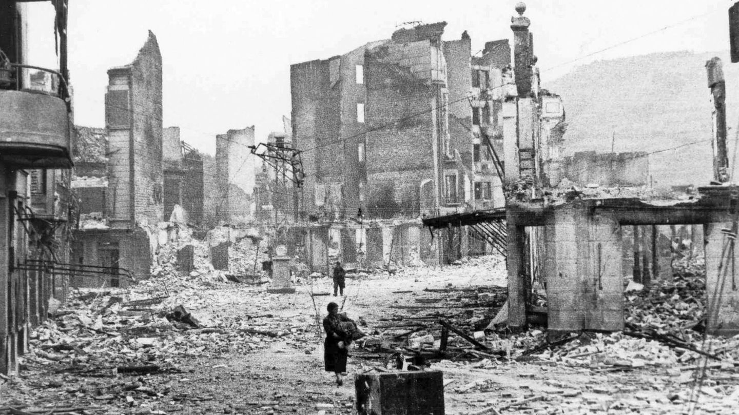 Zwei Menschen irren nach dem Angriff durch das von deutschen und italienischen Bombern heimgesuchte Guernica