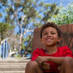 Ein Junge sitzt auf einer Treppenstufe