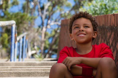 Ein Junge sitzt auf einer Treppenstufe