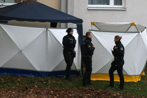 Polizisten stehen vor dem Sichtschutz an der Unglücksstelle in Bremen
