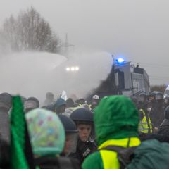 Die Polizei setzt Wasserwerfer gegen Demonstranten ein, die die B429 nahe der Lahnbrücke blockieren. Foto: Lando Hass/dpa