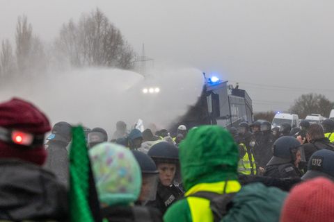 Die Polizei setzt Wasserwerfer gegen Demonstranten ein, die die B429 nahe der Lahnbrücke blockieren. Foto: Lando Hass/dpa