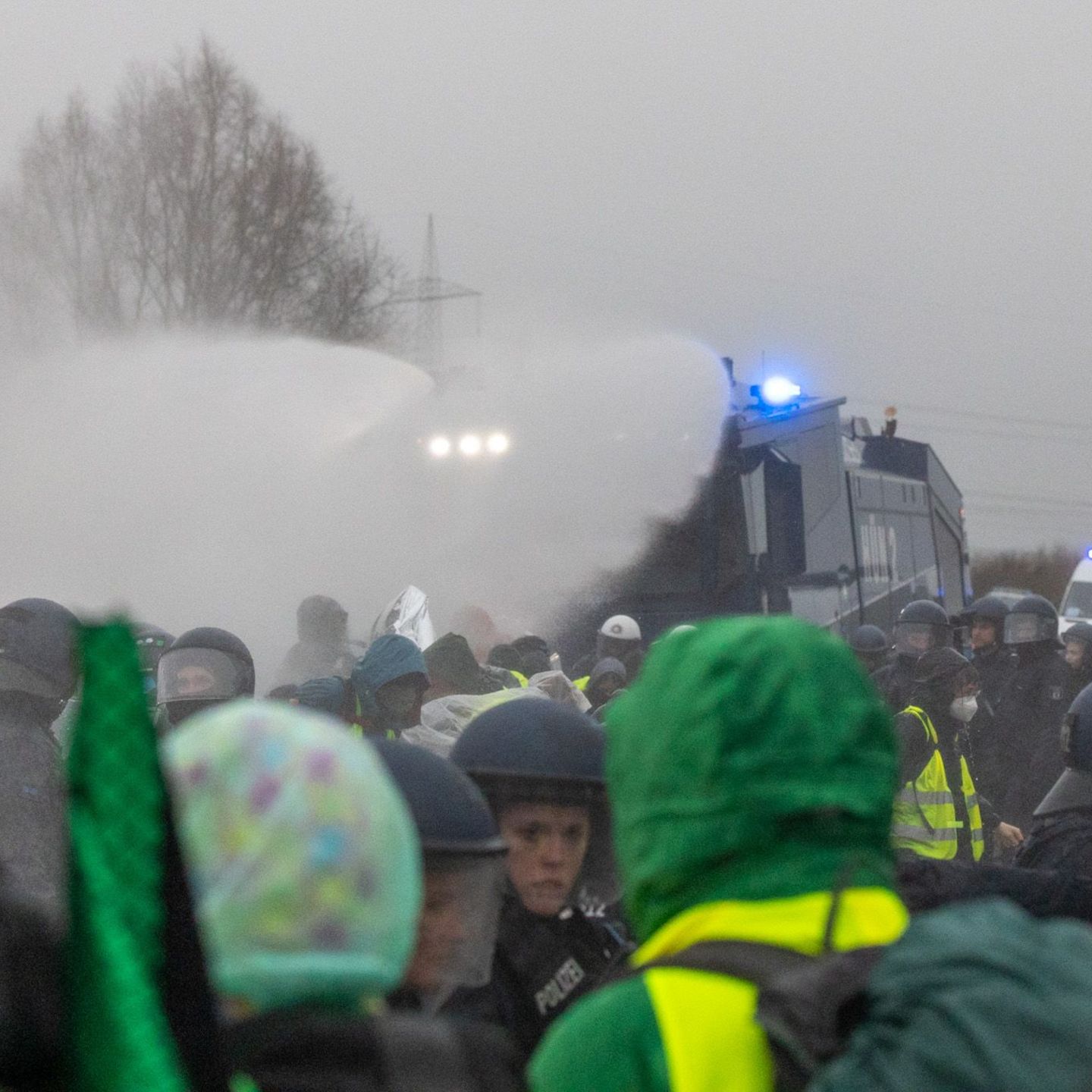 Die Polizei setzt Wasserwerfer gegen Demonstranten ein, die die B429 nahe der Lahnbrücke blockieren. Foto: Lando Hass/dpa