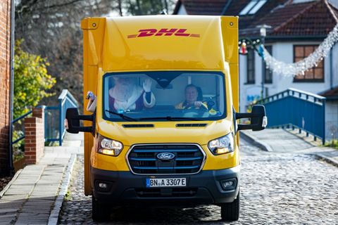 Mann in Weihnachtsmann-Kostüm in DHL-Fahrzeug