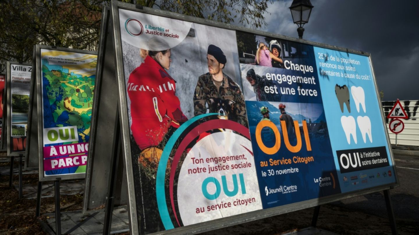 Des affiches électorales en faveur d'une initiative instaurant le devoir civique obligatoire pour tous dans une rue à Genève, le