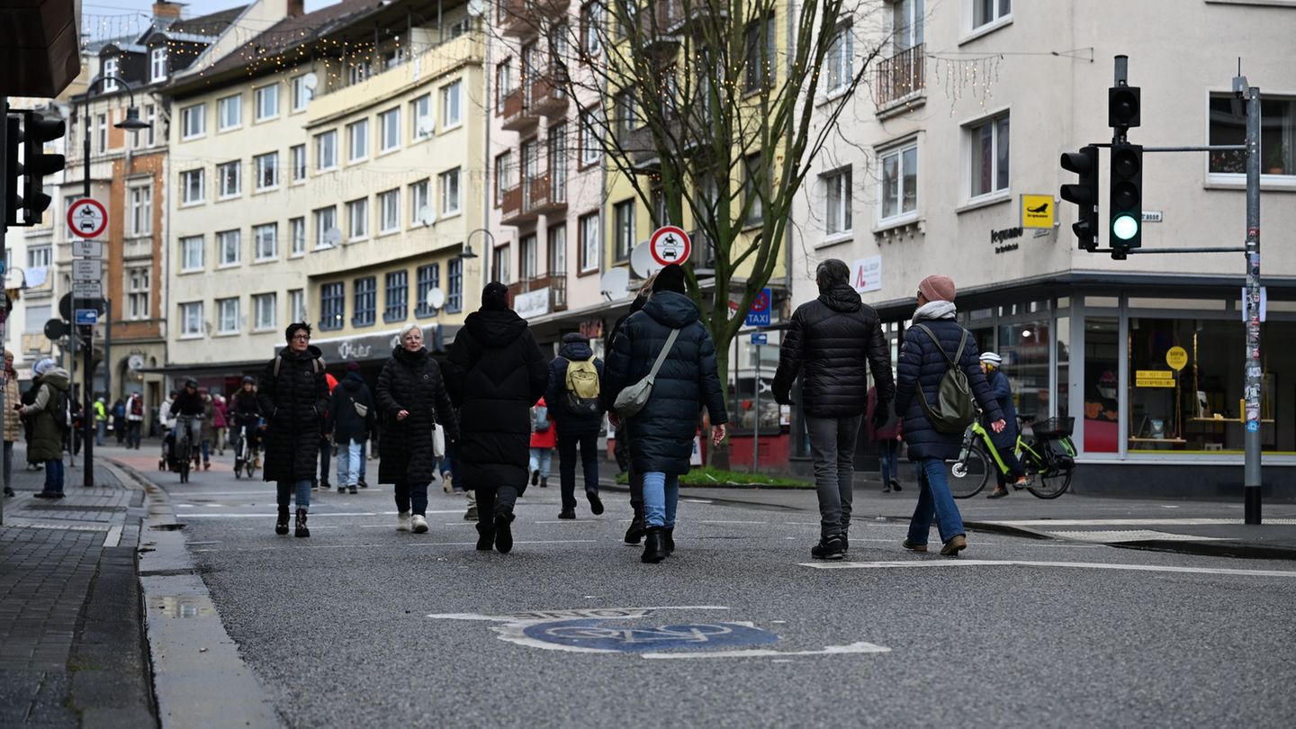 Auf abgesperrten Straßen gehen Passanten durch die Innenstadt von Gießen. Foto: Michael Brandt/dpa