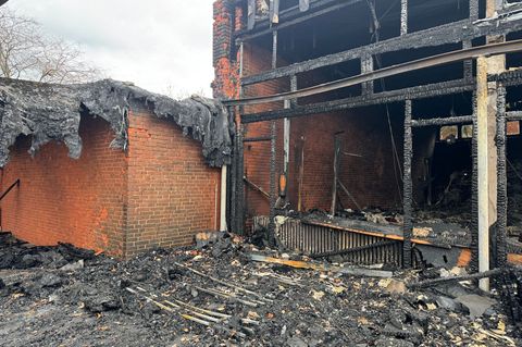 Vor der zerstörten Aula zeigt sich das Ausmaß des Brandes deutlich. Foto: Kilian Genius/dpa