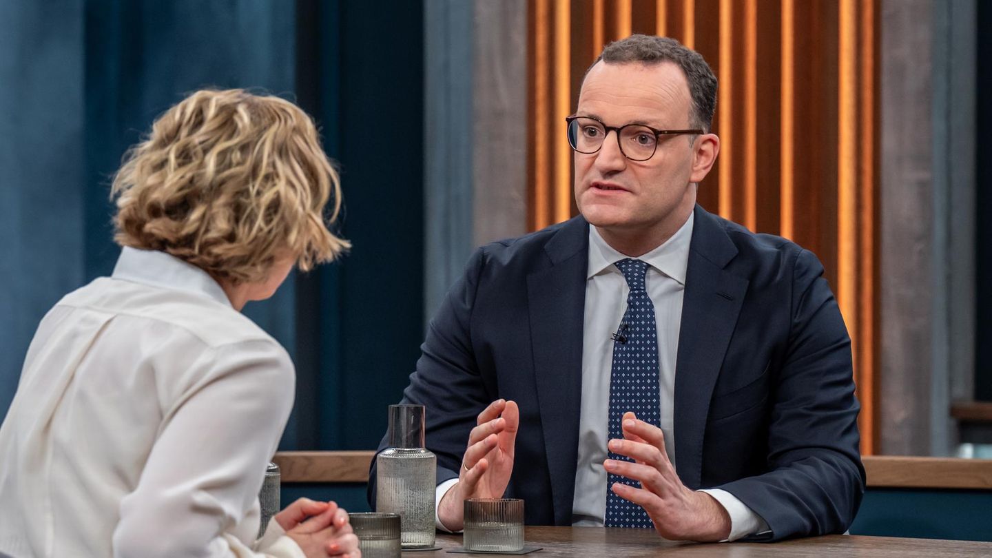 Jens Spahn sitzt an einem Tisch mit Caren Miosga und gestikuliert mit beiden Händen beim Reden