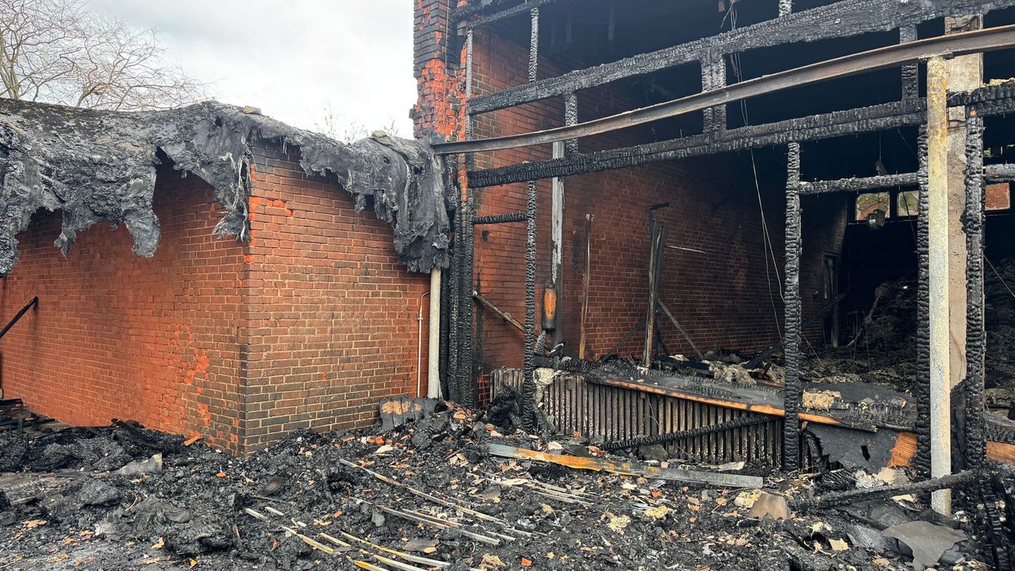 Vor der zerstörten Aula zeigt sich das Ausmaß des Brandes deutlich. Foto: Kilian Genius/dpa