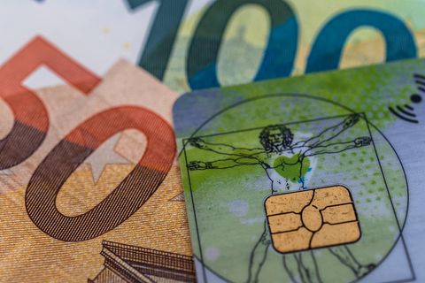 Krankenkassen Symbolbild: Ausschnitt einer Gesundheitskarte und eines 50- und 100-Euro-Scheins