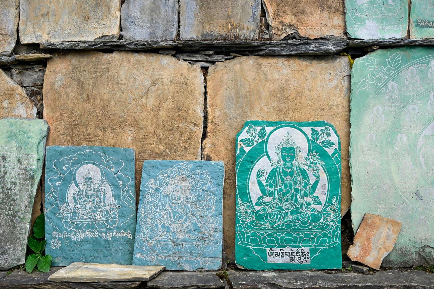 An vielen Stupas, also kleinen Denkmälern entlang des Weges, lehnen Schieferntafeln mit buddhistischen Motiven