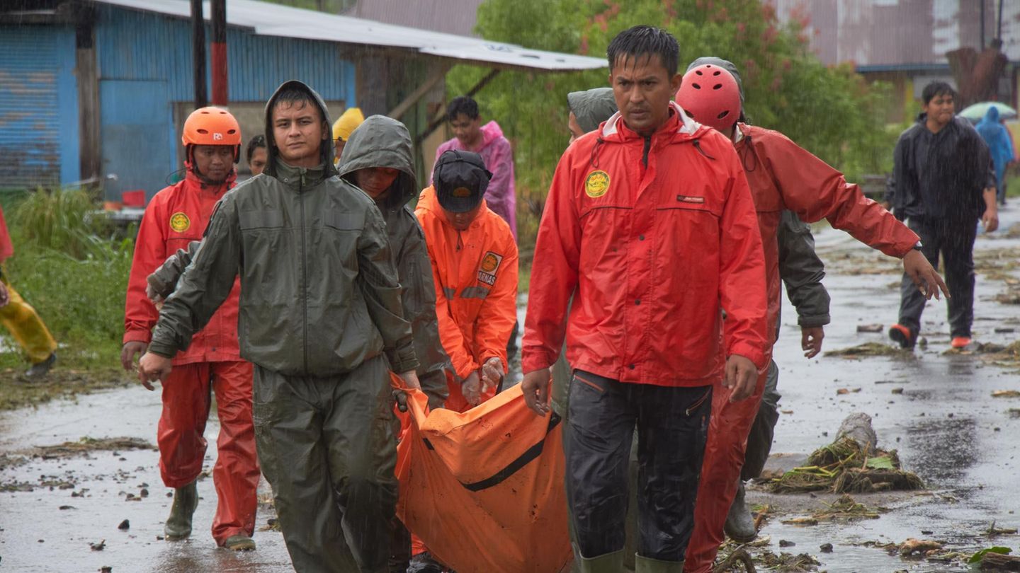 Rettungskräfte tragen die Leiche eines Opfers in einem überschwemmten Dorf in Westsumatra