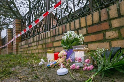 Kerzen und Blumen liegen vor einem Haus in Berlin-Mahlsdorf, in dem nach einem Feuer ein Kind gestorben ist. Foto: Jens Kalaene/